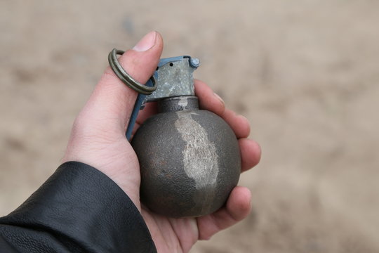 american combat grenade in hand