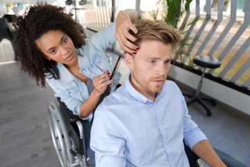 Obraz premium a professional hairdresser in wheelchair