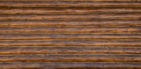 Texture of a wooden log surface. Old planed logs. The wall of the old house