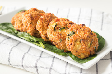 Patties made from millet and vegetables on white plate