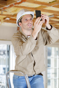 builder man talking pictures of a structure