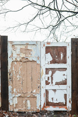 Two old weathered wooden doors fence