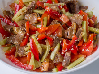 Korean meat salad close-up. Juicy salad of beef, cucumbers, peppers. Beautiful food
