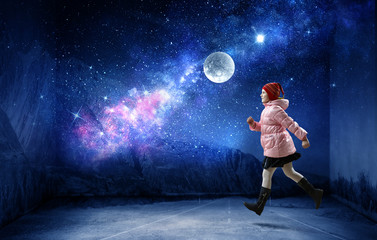 A little girl walks on a beautiful full moon night.