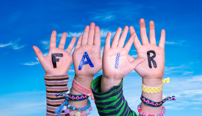 Children Hands Building Colorful Word Fair. Blue Sky As Background
