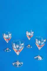 Empty glasses on blue background. Flat lay, copy space, top view.