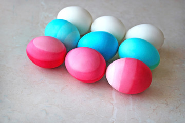 Fototapeta na wymiar White, blue and pink Easter eggs on the table. Season's greetings card. Modern easter flat lay.
