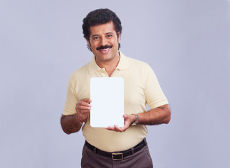 Man in happy mood showing a small placard in hand. 