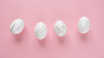 Fototapeta na wymiar White easter eggs with silver pattern on pink