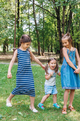 Obraz premium Happy active kids playing on green grass in spring park