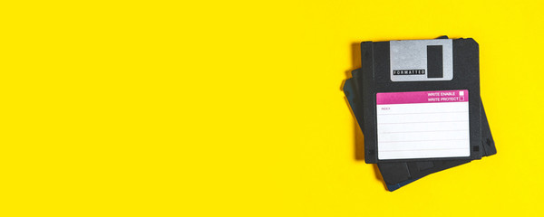 Old floppy disks for computer on yellow background