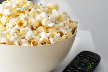 Close up of Popcorn bowl and remote control.Detail baclground.wanthicg tv at home concept.