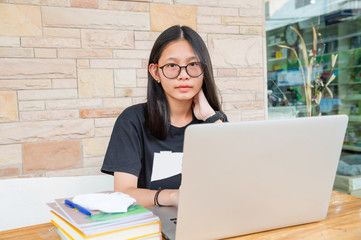 social distancing student concept, Junior high school girl Do homework at home with laptop. the school is closed during an outbreak of the Coronavirus Covid-19 and Dust PM2.5 in Bangkok Thailand 