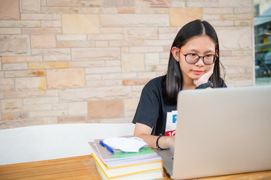 Social Distancing Student Concept, Junior High School Girl Do Homework At Home With Laptop. The School Is Closed During An Outbreak Of The Coronavirus Covid-19 And Dust PM2.5 In Bangkok Thailand 