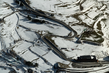 Aerial view of the road in winter, road surrounded by trees, car in winter. Rural winter area