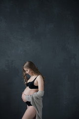 Fototapeta na wymiar Pensive pregnant woman dreaming about child. Young happy expectant girl thinking about her baby and enjoying her future life. Motherhood, pregnancy, happiness concept, copy space