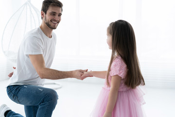 I love you, dad! Handsome young man is dancing at home with his little girl. Happy Father's Day!