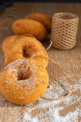 Top view of donuts with rope and sugar roll on wooden table in vertical