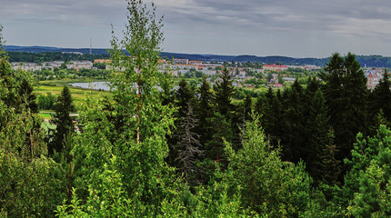 Fototapeta na wymiar Panorama of the city from a height.Panoramic view of the city of Sortavala from a hill in a city park: a forest of conifers, traces of volcanic lava, rocks and volcanic rocks. Russia, Karelia