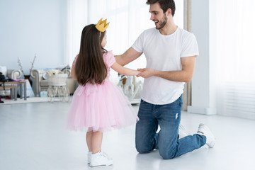 I love you, dad! Handsome young man is dancing at home with his little girl. Happy Father's Day!