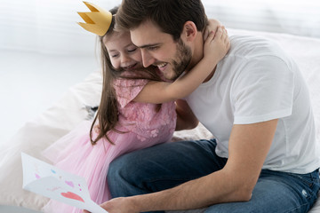 Father's day. Happy family daughter giving dad a greeting card on holiday.