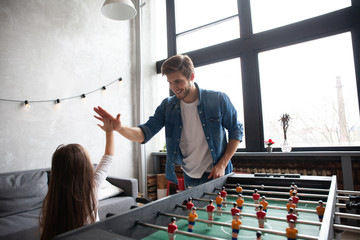 father and daughter playing table football at home