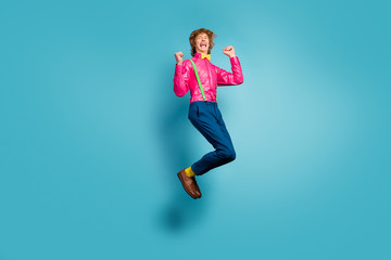 Full size photo of delighted crazy girl win discount lottery enjoy rejoice raise fists scream yeah wear pink pants trousers footwear isolated over blue color background