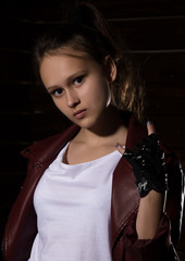 Beautyful Girl in leather jacket in a dark. Mysterious disobedient child, problems with early growing girls