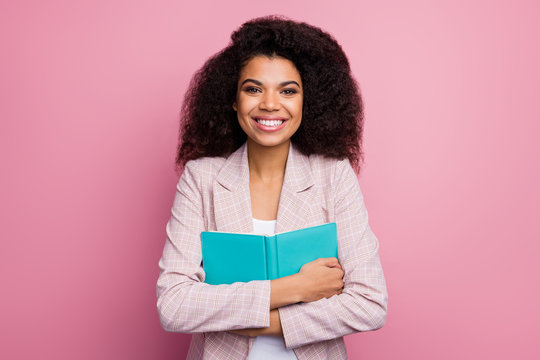 Photo of funny pretty dark skin lady hold journal book close to chest reader dreamer live positive emotions feelings wear checkered blazer isolated pastel pink color background