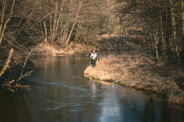 Obraz na płótnie Canvas Fisherman and his dog on the river bank.