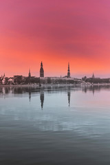 Naklejka premium Cityscape of Riga Latvia with Reflections on a Quiet Still River at Sunset