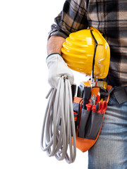 Electrician holds the roll of electric cable in his hand, helmet with protective goggles....