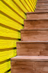 A brown wooden stair with yellow wooden wall