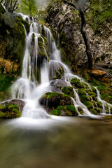 Naklejka na ściany i meble Long exposure of a beautiful waterfall with green moss, Beusnita, Cheile Nerei National Park, Romania