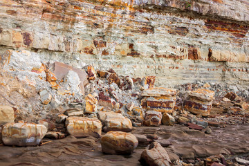 Rockfalls from crumbling sandstone cliff