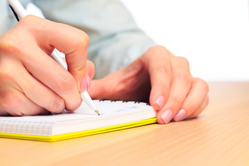 female hands write in a notebook . Office place  - Image