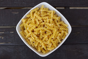 Italian typical kind of pasta, fusilli, on wooden table with natural light
