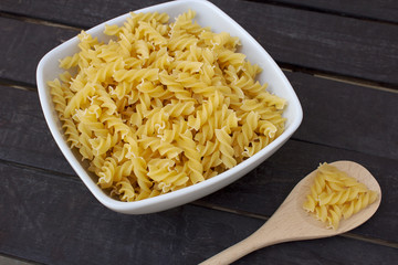 Italian typical kind of pasta, fusilli, on wooden table with natural light