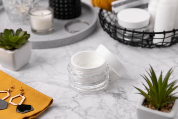 Cosmetic bottle containers with yellow towels and accessories on marble table