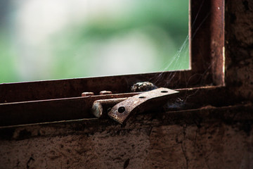 Old window wiith cobwebs in an abandoned building in Dschang