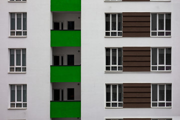 Fototapeta premium Building facade with windows and green balconies. Flat view pattern. Modern urban architecture background. Mortgage to buy private apartment concept