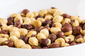 Geröstete Haselnüsse in einer weißen Schüssel (Makro/Detail)