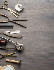 Classic grooming and hairdressing tools on wooden background.