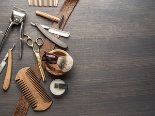 Classic grooming and hairdressing tools on wooden background.