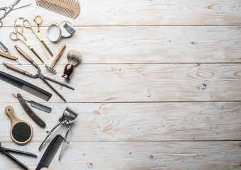 Classic grooming and hairdressing tools on wooden background.