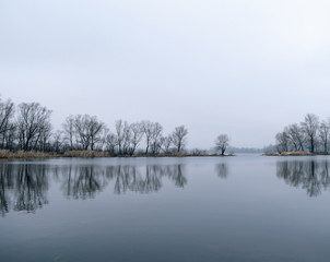 Lake with reflection of trees. Cold morning