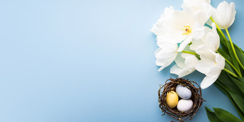 Naturally colorful dyed Easter eggs on blue background. Happy Easter holiday theme, banner	