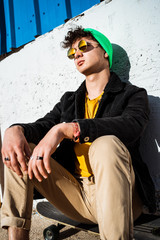 Guy with skateboard on the street dressed modern