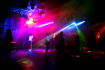 blurred silhouettes of people dancing in a nightclub