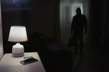 Burglar inside of a house with flashlight                